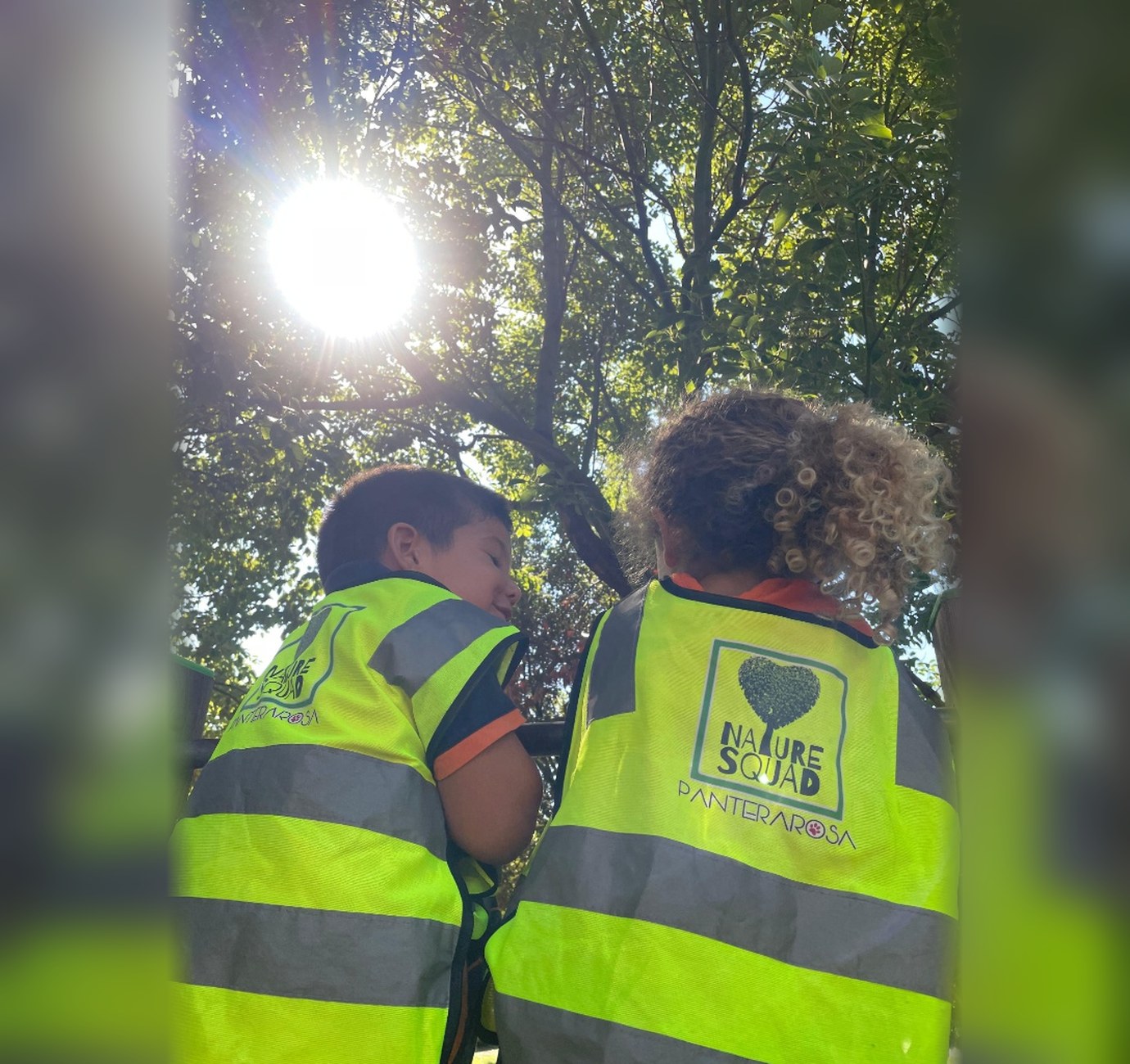 Bambini con le pettorine gialle corrono felici tra gli alberi